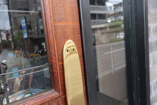 ナチュラルな木製ドアに取り付けた真鍮押板ks18の使用例